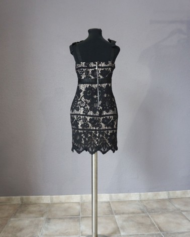 Vestido de fiesta corto de encaje negro sobre fondo claro