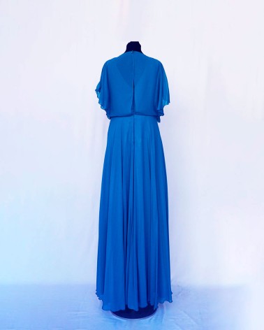 Vestido largo en gasa azul con capa tipo bolero y cinturilla joya