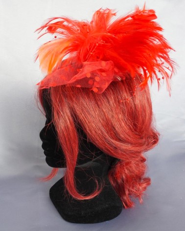 Tocado coral con plumas bicolor y tul plumeti para invitada