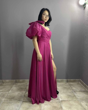 Vestido largo fucsia con escote asimétrico, manga abullonada y abertura lateral
