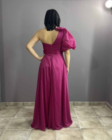 Vestido largo fucsia con escote asimétrico, manga abullonada y abertura lateral