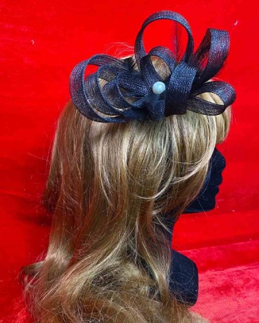 Tocado negro con lazo estructurado para eventos y bodas elegantes