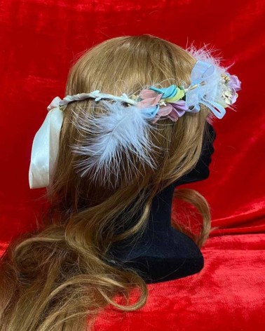 Diadema floral pastel con plumas blancas y lazo de organza