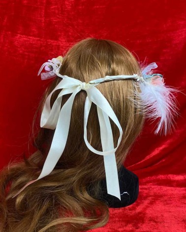 Diadema floral pastel con plumas blancas y lazo de organza