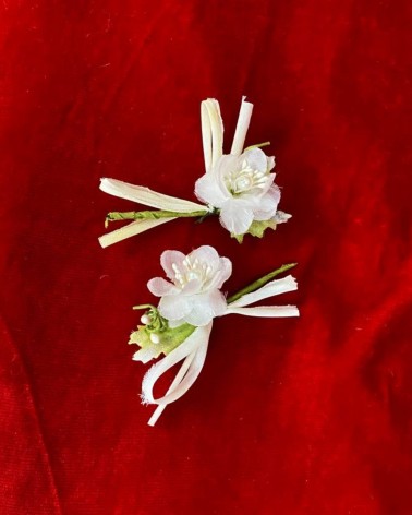 Flores blancas con ramitas verdes y lazos de rafia para novia