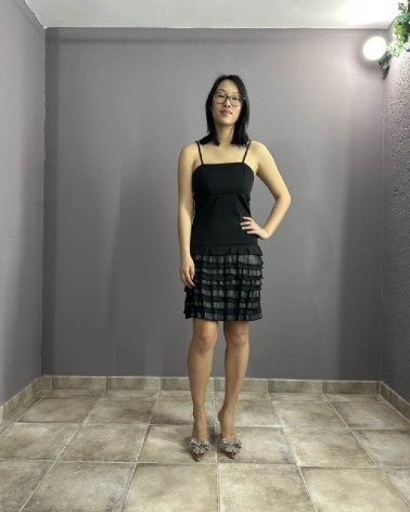 Vestido corto negro con tirantes y falda de volantes plisados
