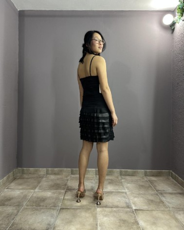 Vestido corto negro con tirantes y falda de volantes plisados