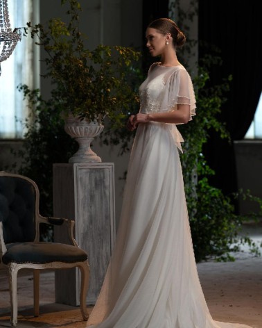 Vestido de novia vaporoso con cuerpo bordado y mangas capa de tul