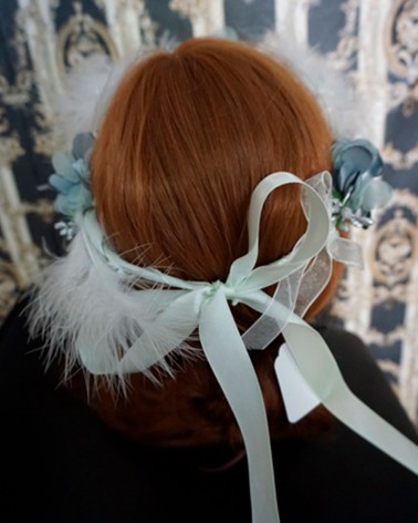 Corona floral con plumas en tonos celeste y blanco